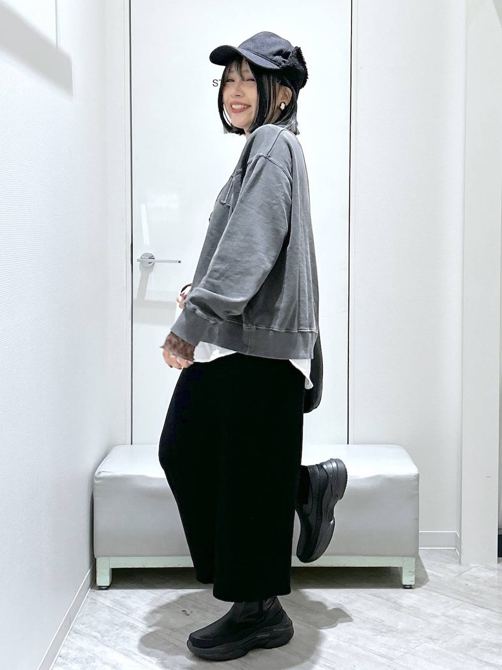 ブラック系のショルダーバッグ、ブラック系のブーツ、ブラック系のスカートを着用したレディースの秋コーディネートの2枚目の写真