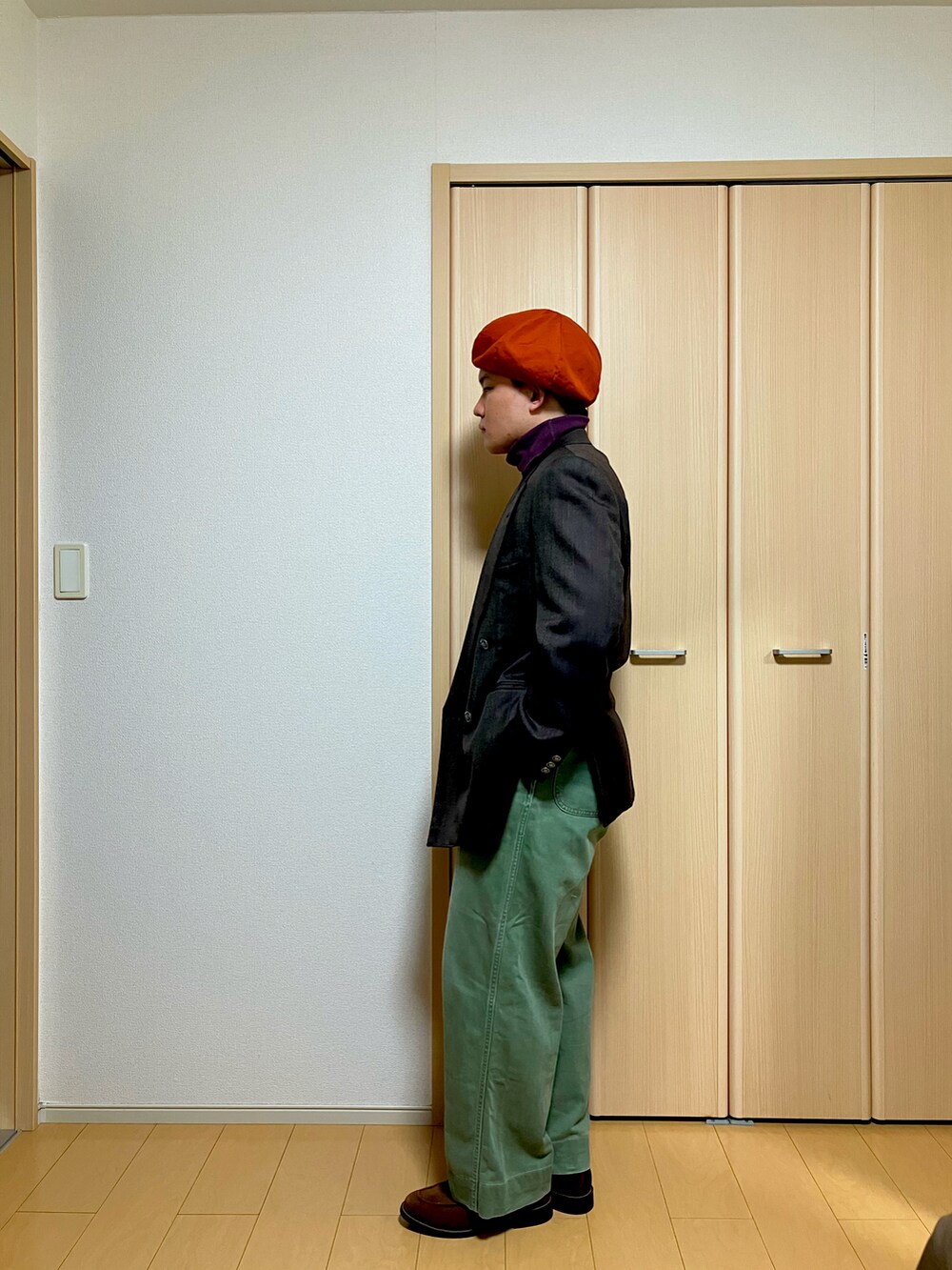 ブラウン系のテーラードジャケット、グリーン系のチノパンツ、ブラウン系のローファーを着用したメンズの冬コーディネートの3枚目の写真