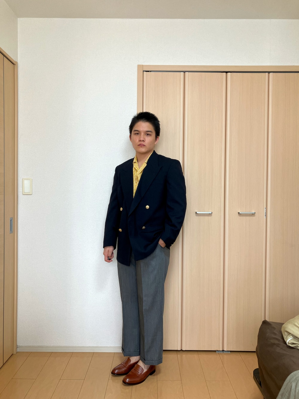 ブラウン系のローファー、グレー系のスラックス、イエロー系のシャツ/ブラウスを着用したメンズの夏コーディネートの2枚目の写真