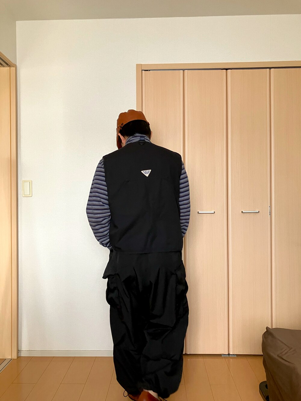 ブラック系のその他アウター、ベージュ系のカーゴパンツ、グレー系のTシャツ/カットソーを着用したメンズの秋コーディネートの2枚目の写真