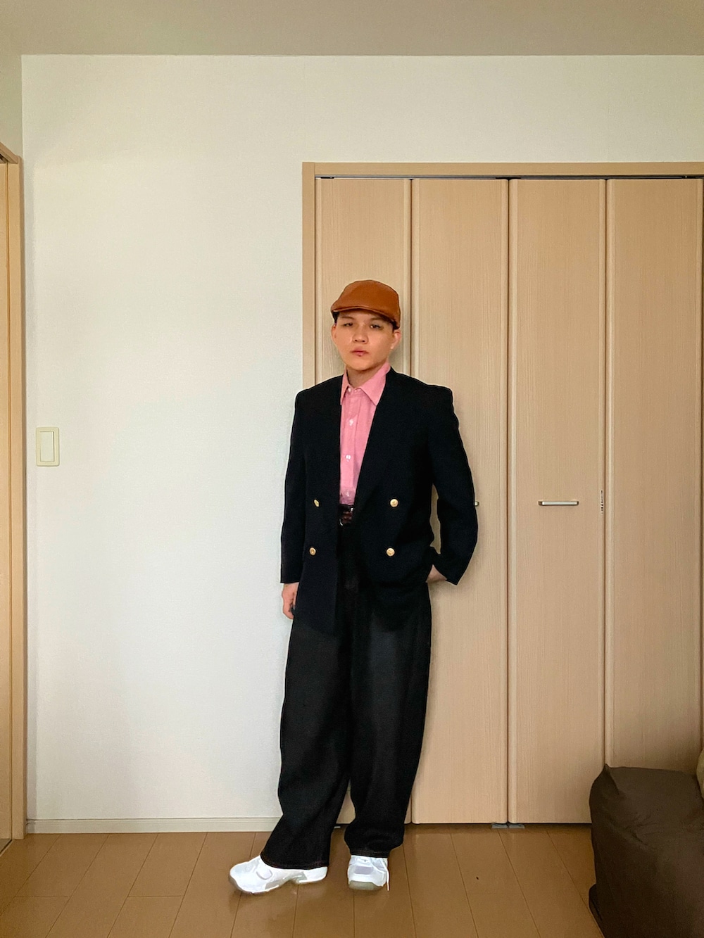ブルー系のテーラードジャケット、ブラック系のデニムパンツ、ホワイト系のスニーカーを着用したメンズの秋コーディネートの2枚目の写真