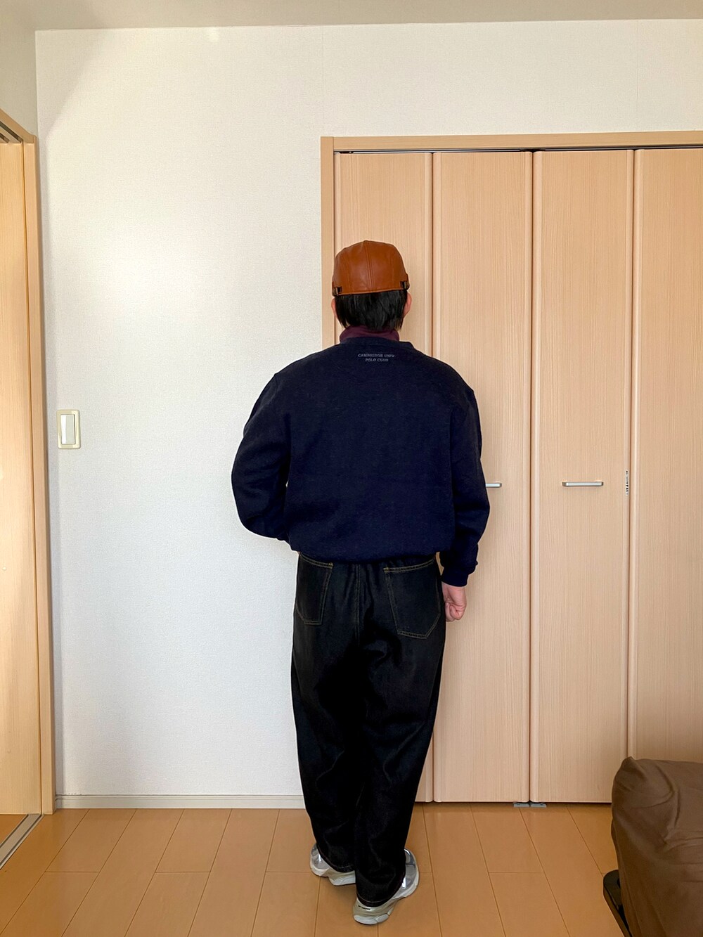 パープル系のトップス、ブルー系のスウェット、ブラック系のデニムパンツを着用したメンズの秋コーディネートの2枚目の写真