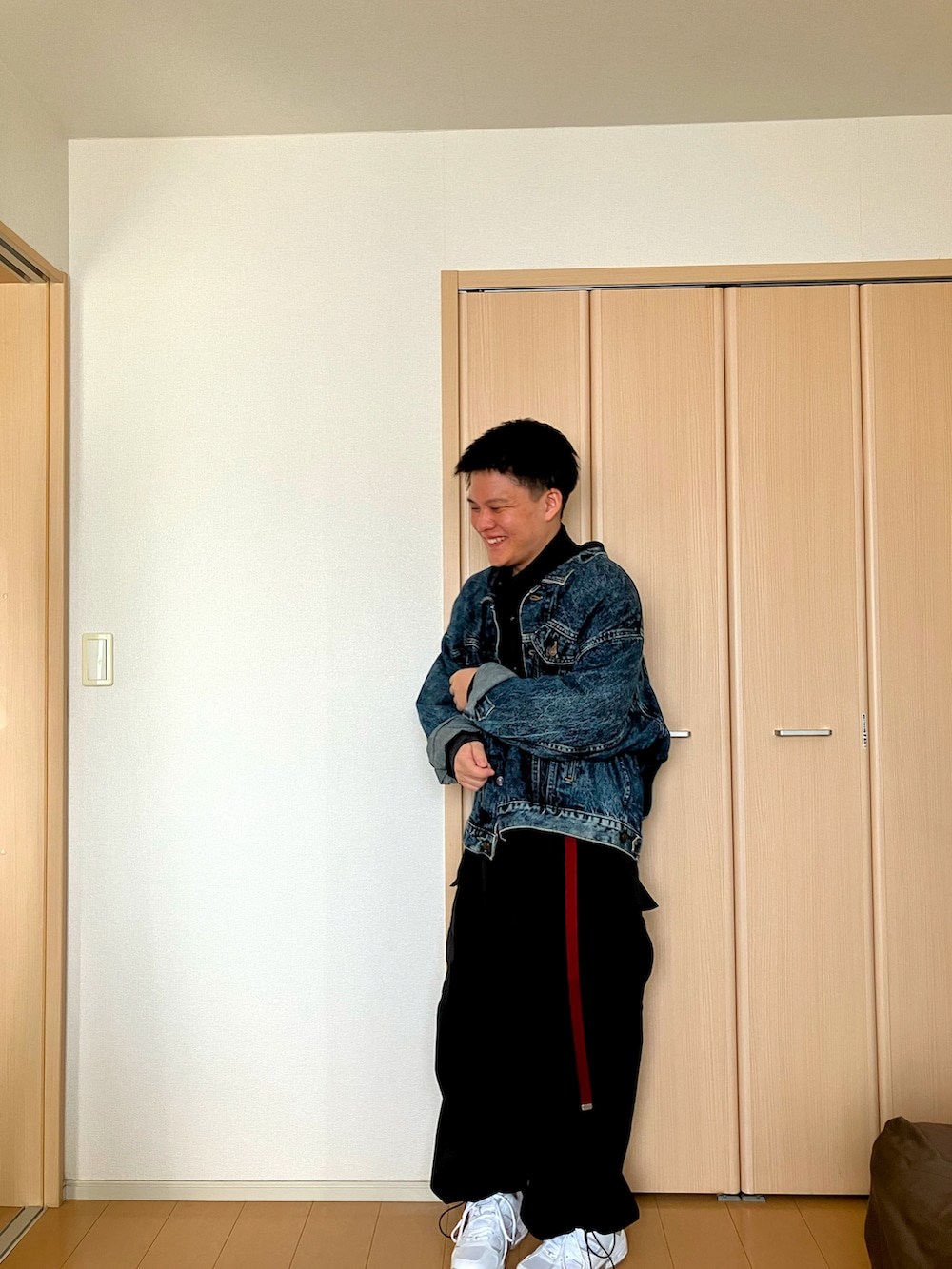 ブルー系のデニムジャケット、ブラック系のシャツ/ブラウス、ベージュ系のカーゴパンツを着用したメンズの秋コーディネートの2枚目の写真