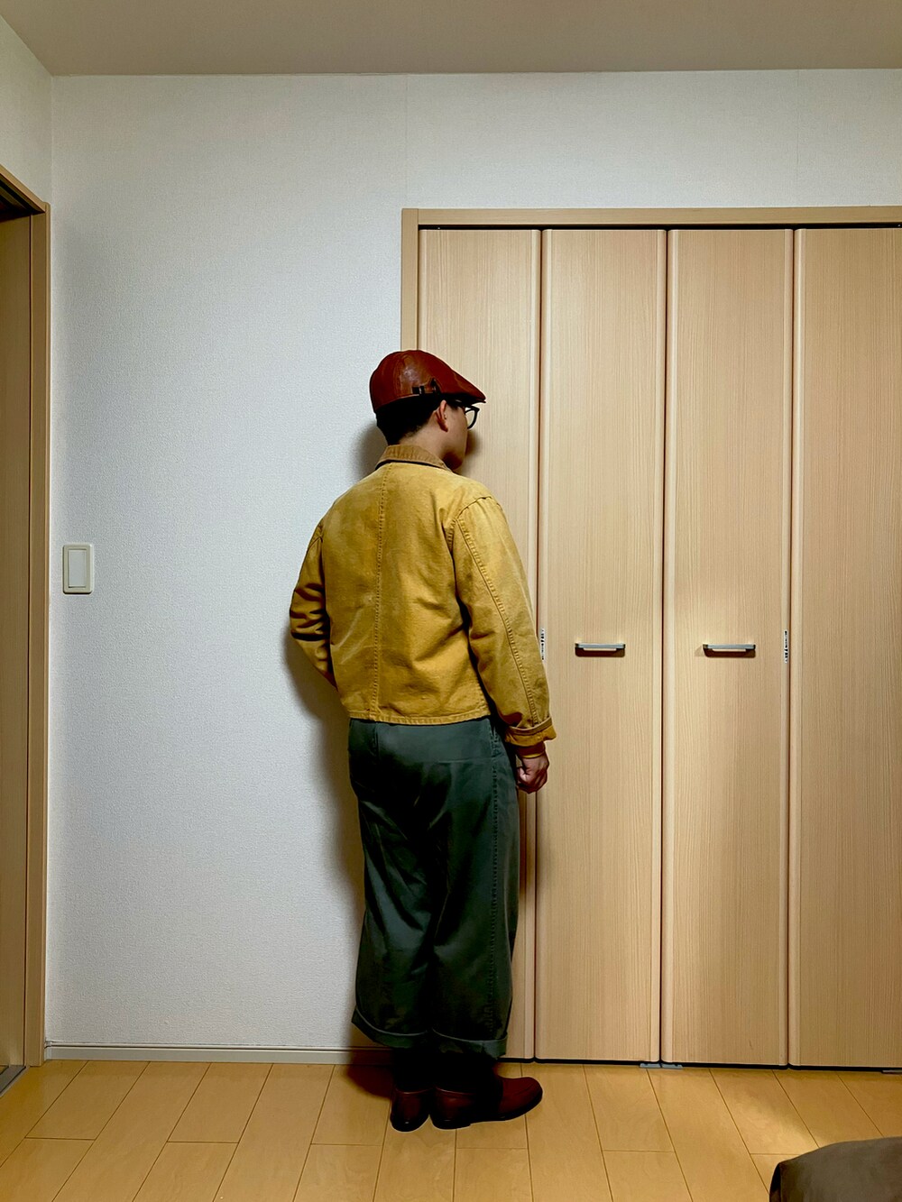グリーン系のチノパンツ、ブラウン系のローファー、イエロー系のTシャツ/カットソーを着用したメンズの冬コーディネートの3枚目の写真