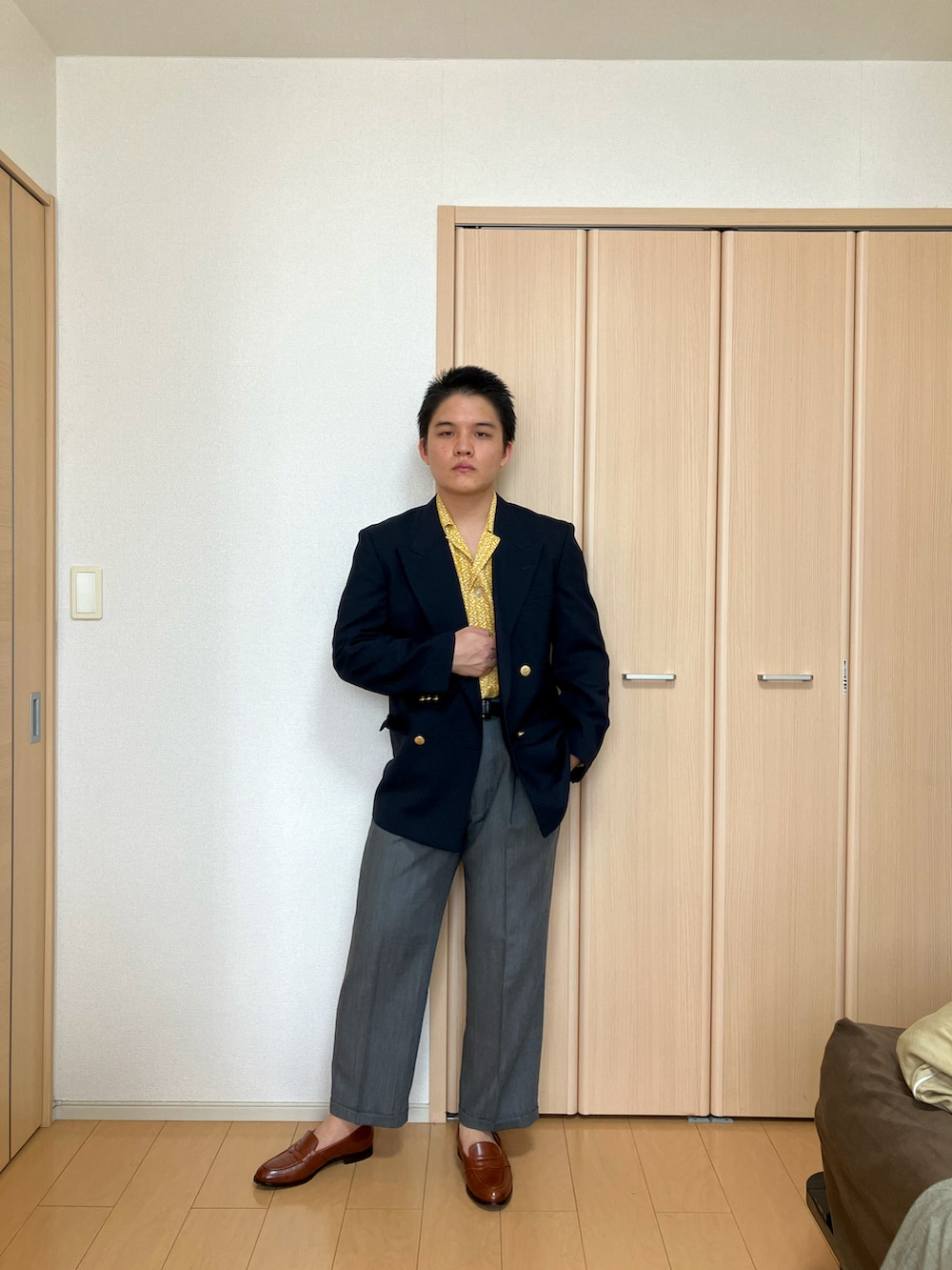 ブラウン系のローファー、グレー系のスラックス、イエロー系のシャツ/ブラウスを着用したメンズの夏コーディネートの3枚目の写真