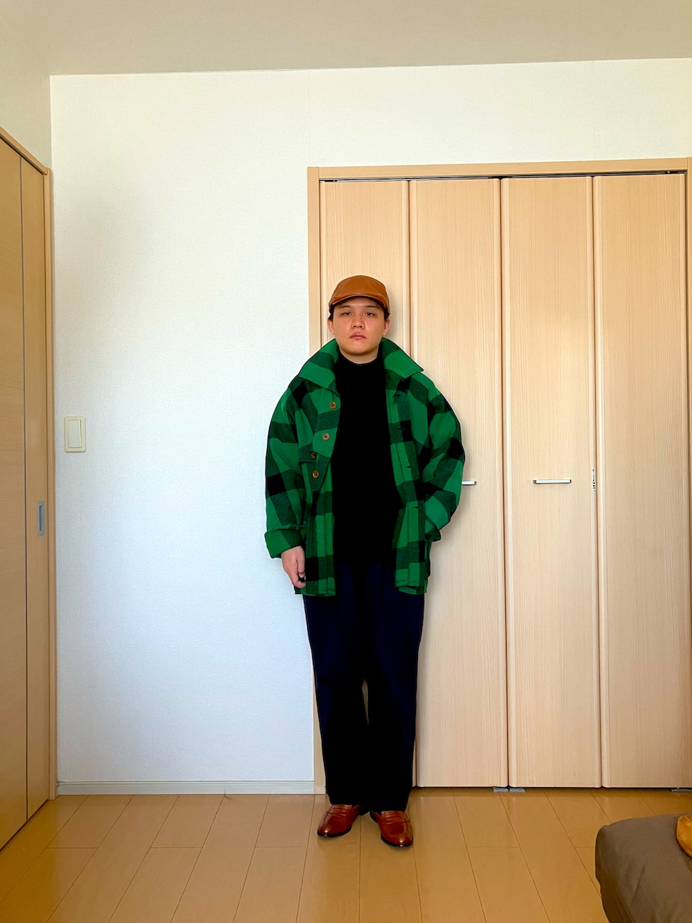 ブルー系のチノパンツ、グリーン系のその他アウター、ブラック系のTシャツ/カットソーを着用したメンズの冬コーディネートの2枚目の写真