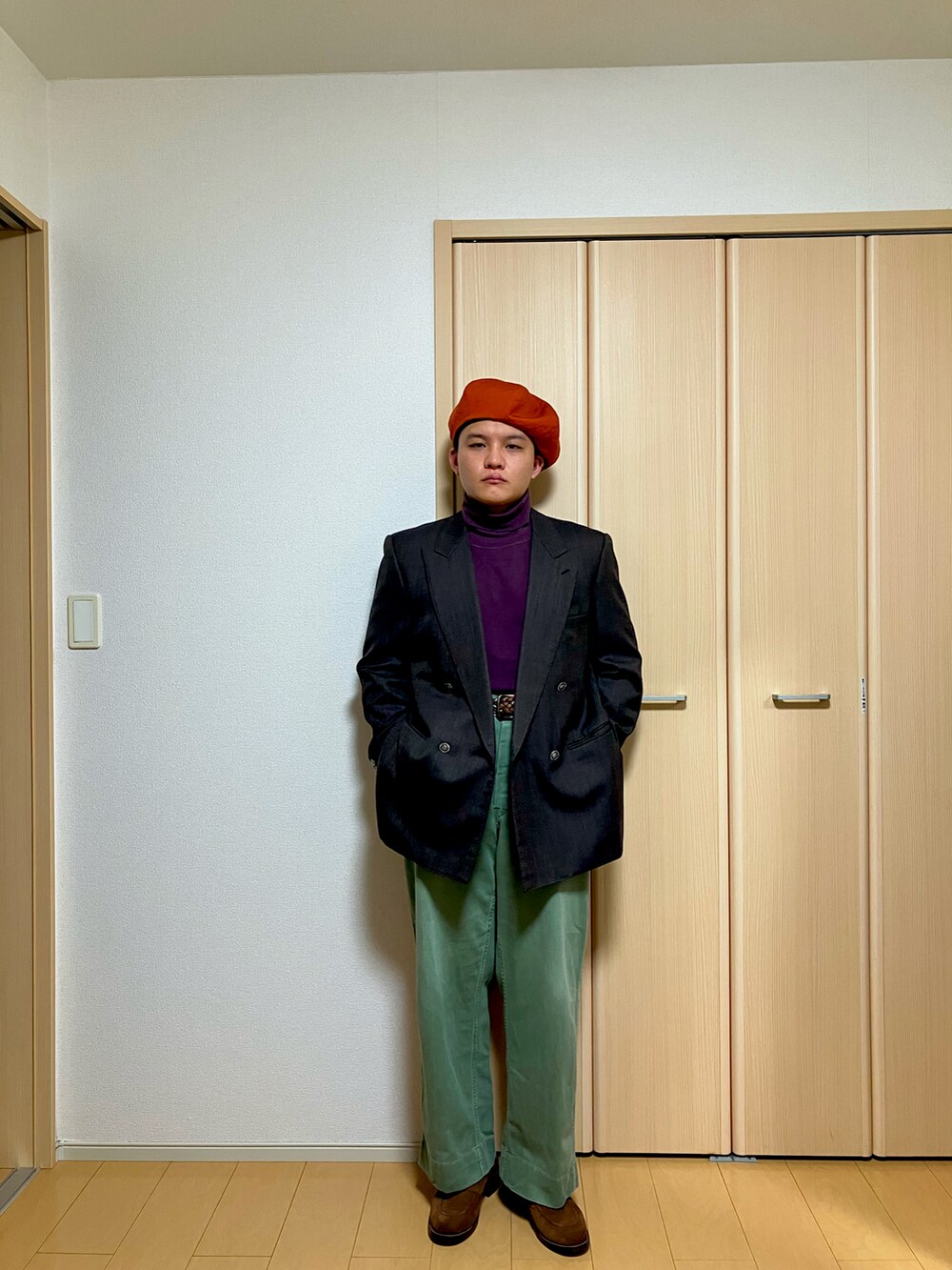 ブラウン系のテーラードジャケット、グリーン系のチノパンツ、ブラウン系のローファーを着用したメンズの冬コーディネートの2枚目の写真