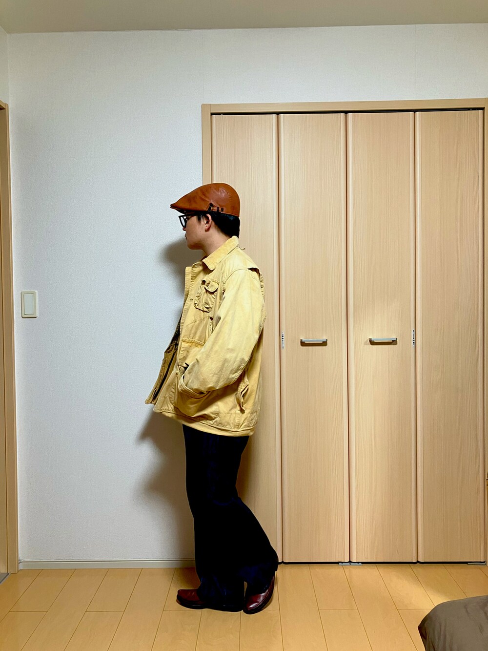 ベージュ系のその他アウター、レッド系のニット/セーター、ブルー系のデニムパンツを着用したメンズの冬コーディネートの2枚目の写真