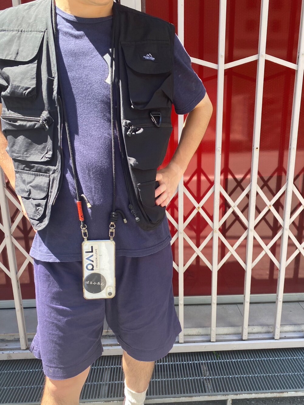 ブラック系のベスト、レッド系のスニーカー、ホワイト系のソックス/靴下を着用したメンズの夏コーディネートの2枚目の写真