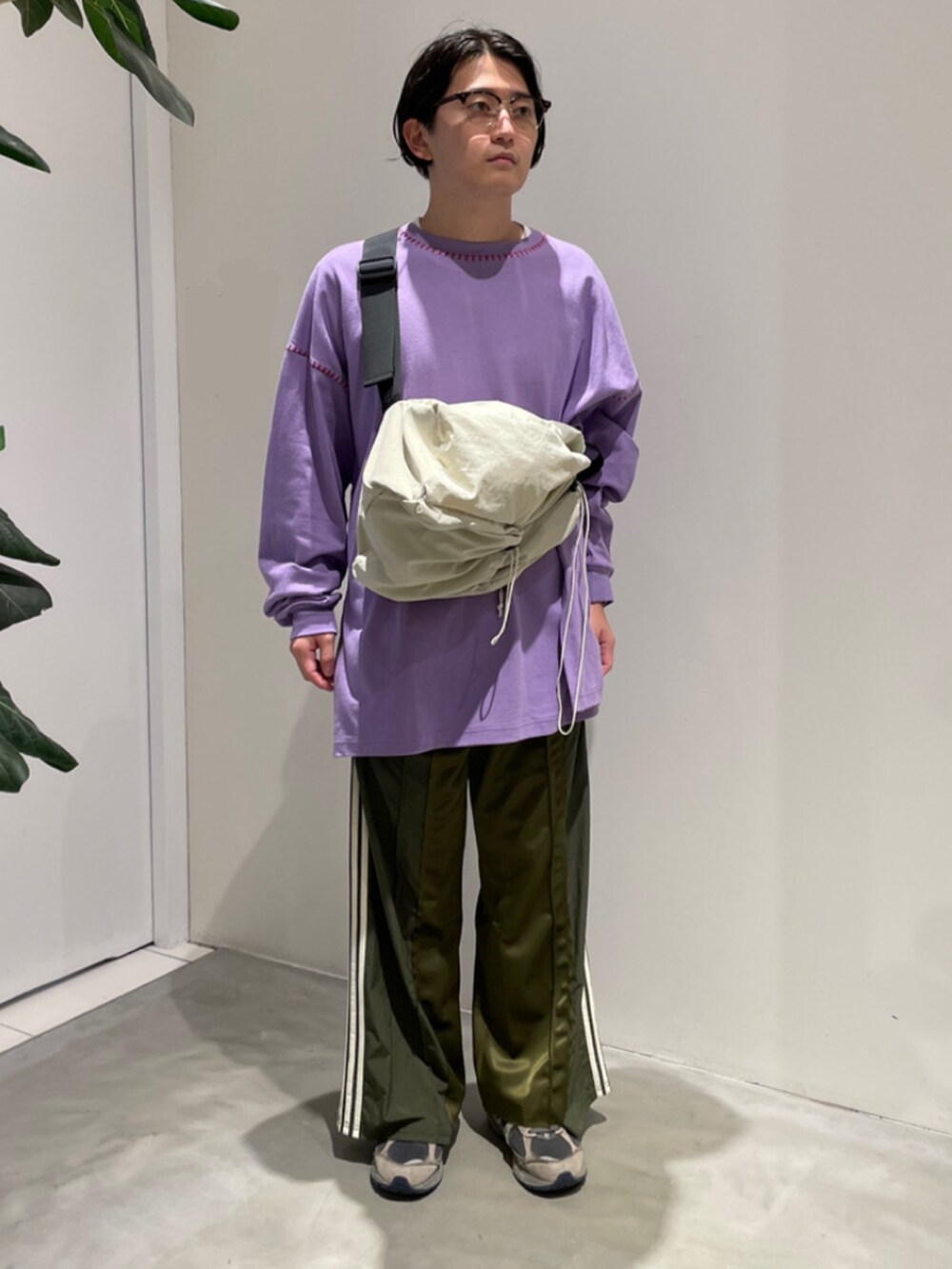 グリーン系のスウェットパンツ、ホワイト系のショルダーバッグ、パープル系のTシャツ/カットソーを着用したメンズの秋コーディネートの2枚目の写真