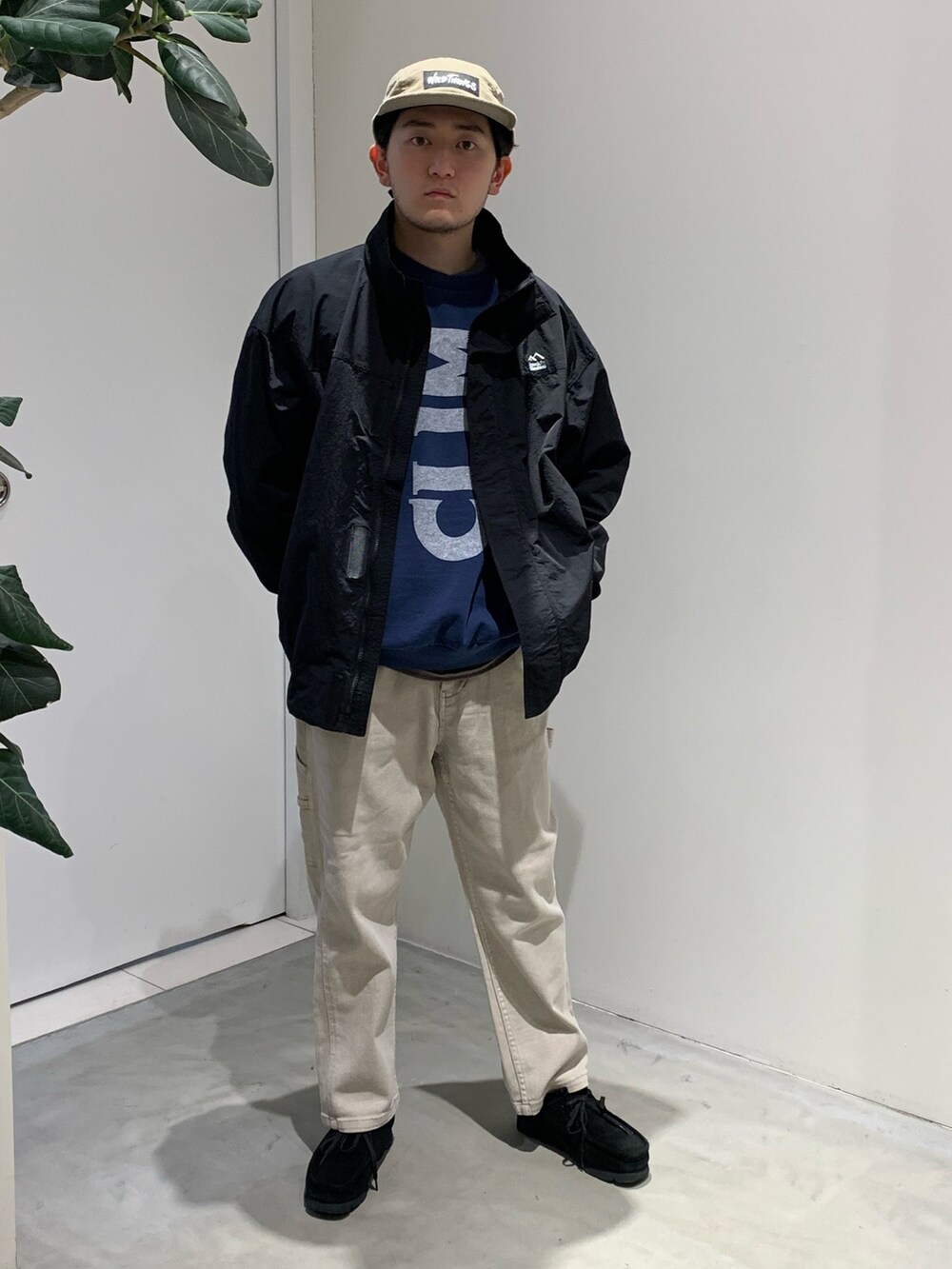 ベージュ系のデニムパンツ、ブラック系のモカシン/デッキシューズ、ブラック系のナイロンジャケットを着用したメンズの春コーディネートの2枚目の写真