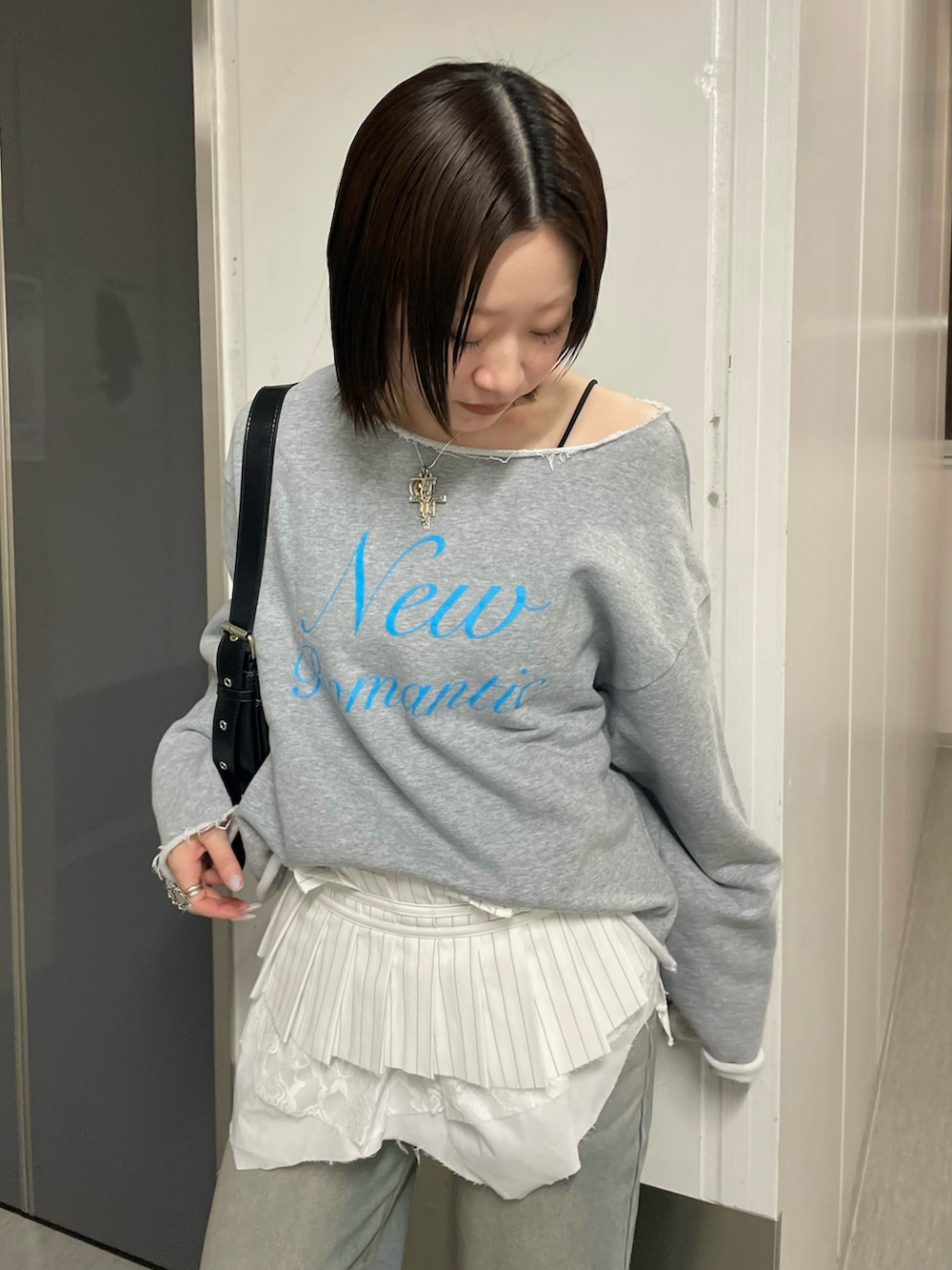 グレー系のスウェット、ブラック系のパンプス、ホワイト系のベルトを着用したレディースの春コーディネートの3枚目の写真