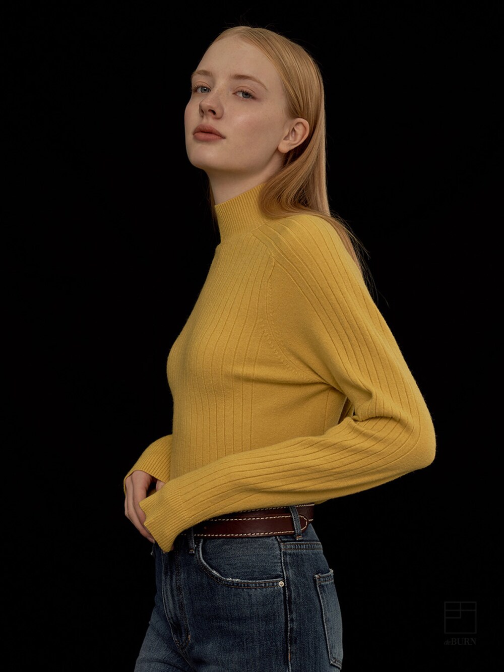 イエロー系のニット/セーターを着用したレディースの冬コーディネートの2枚目の写真