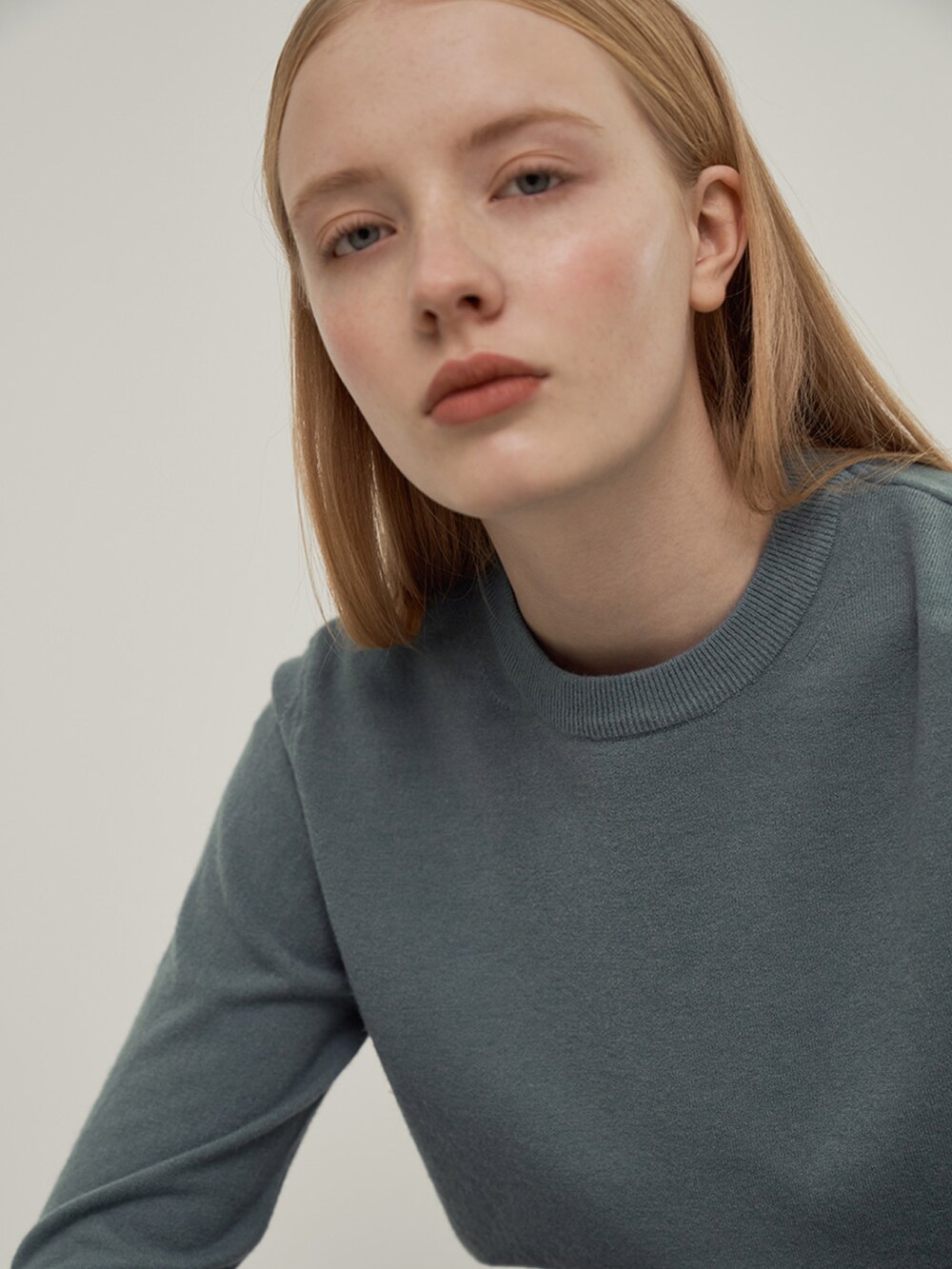 ブルー系のニット/セーターを着用したレディースの冬コーディネートの2枚目の写真