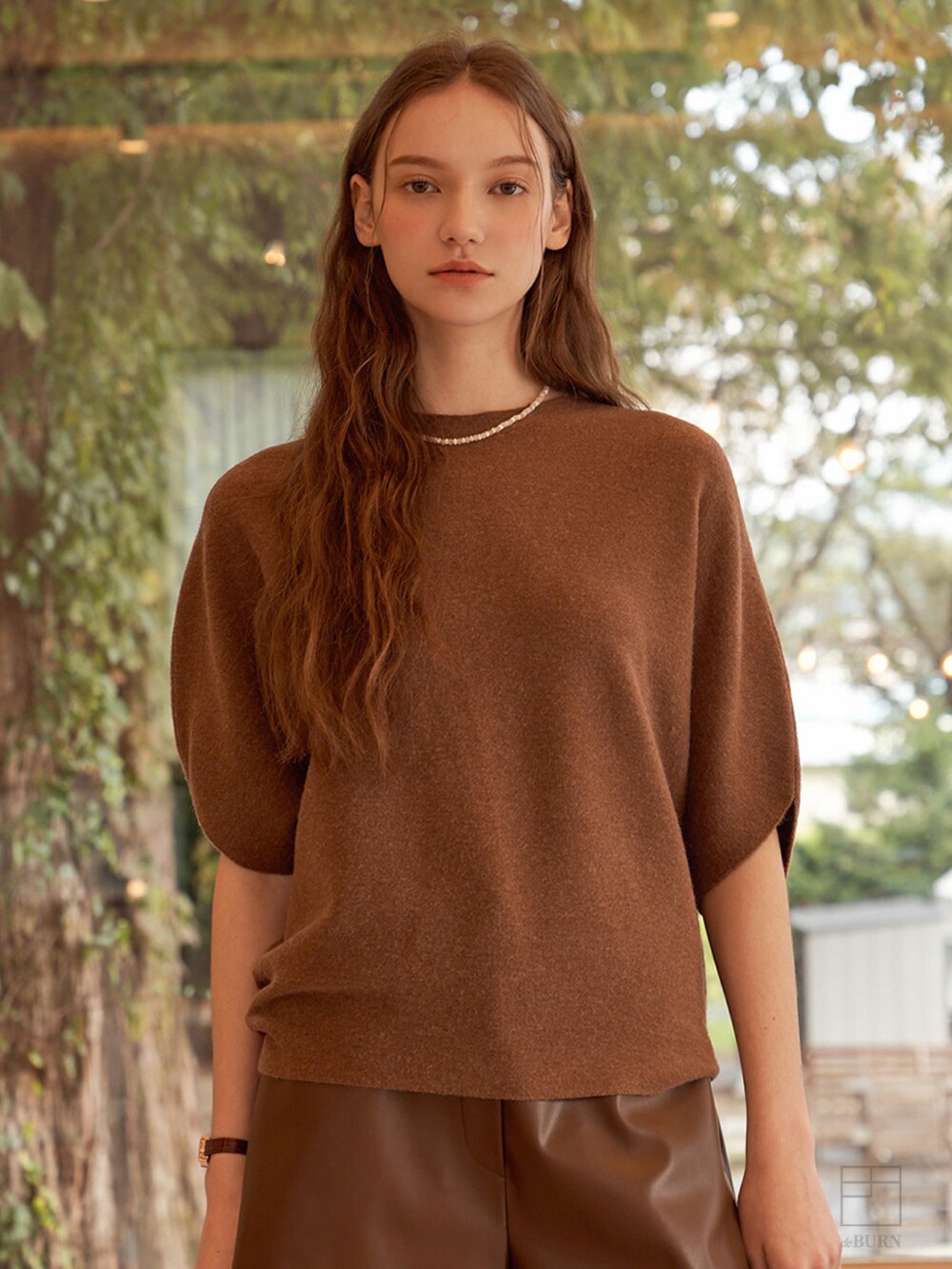 ブラウン系のニット/セーターを着用したレディースの冬コーディネートの2枚目の写真