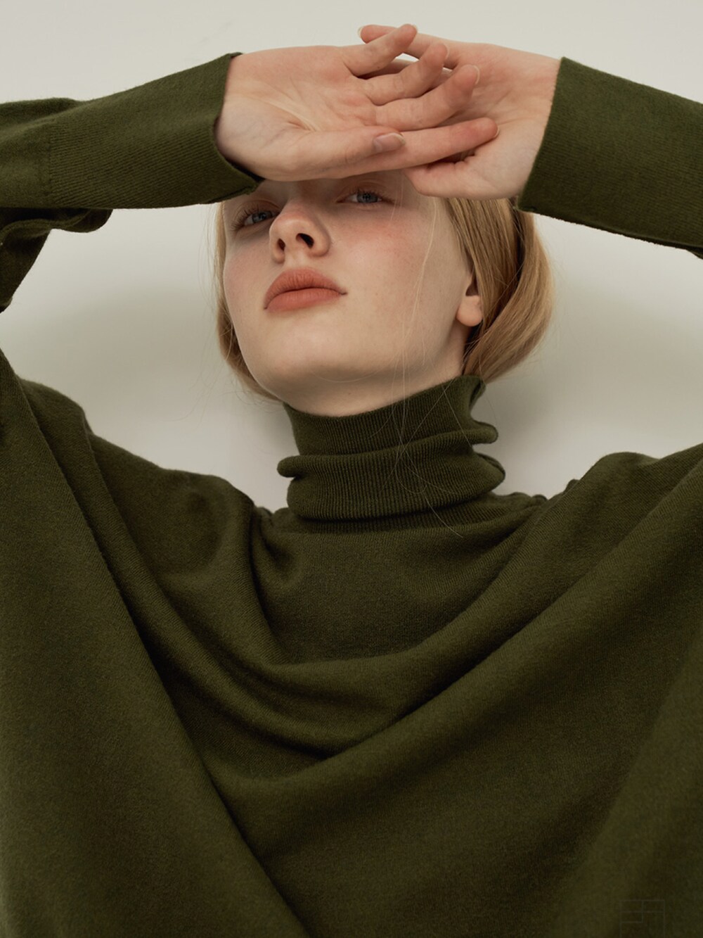 グリーン系のニット/セーターを着用したレディースの冬コーディネートの2枚目の写真