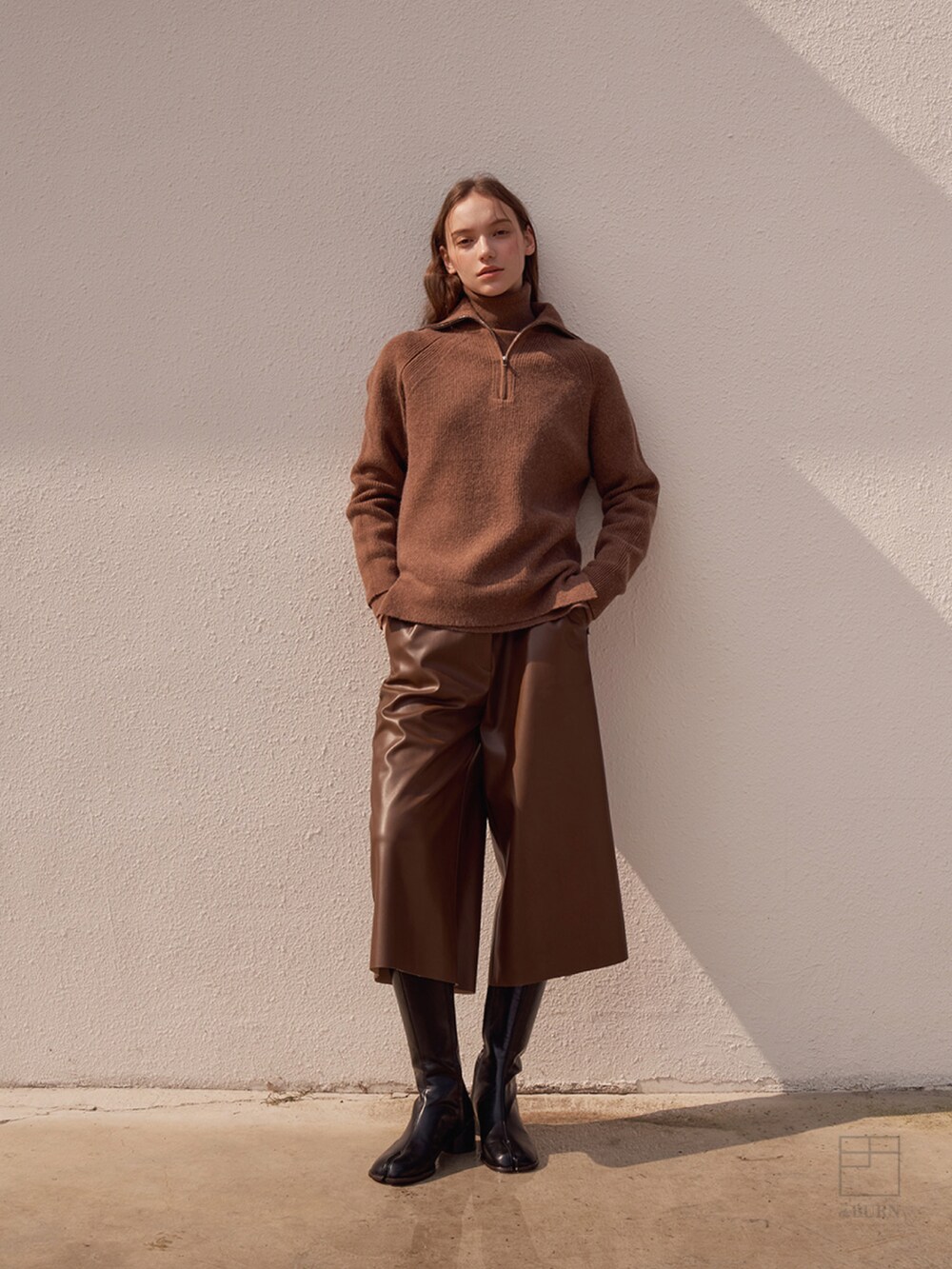 ブラウン系のニット/セーターを着用したレディースの冬コーディネートの3枚目の写真