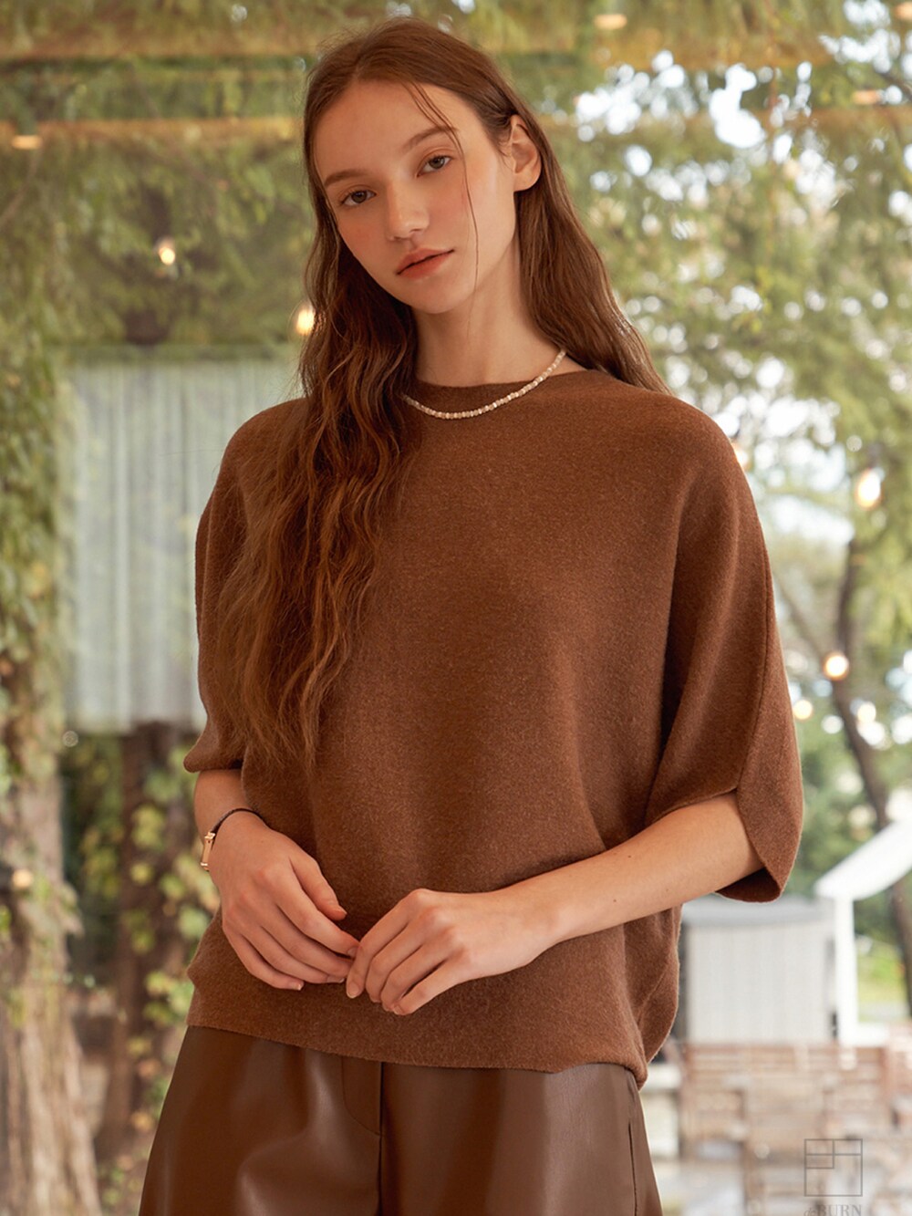 ブラウン系のニット/セーターを着用したレディースの冬コーディネートの5枚目の写真