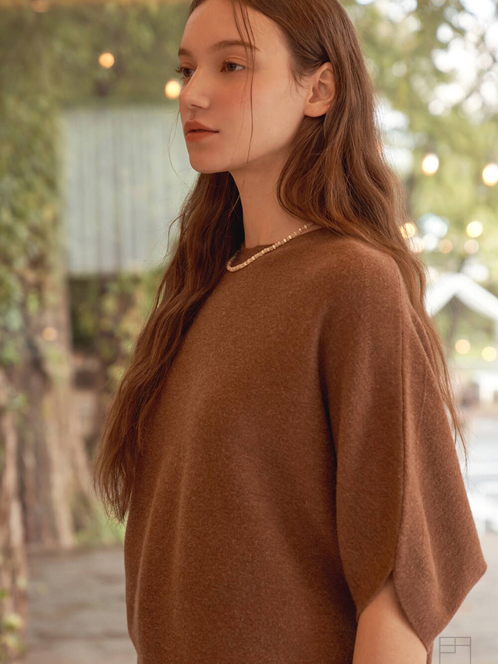 ブラウン系のニット/セーターを着用したレディースの冬コーディネートの3枚目の写真