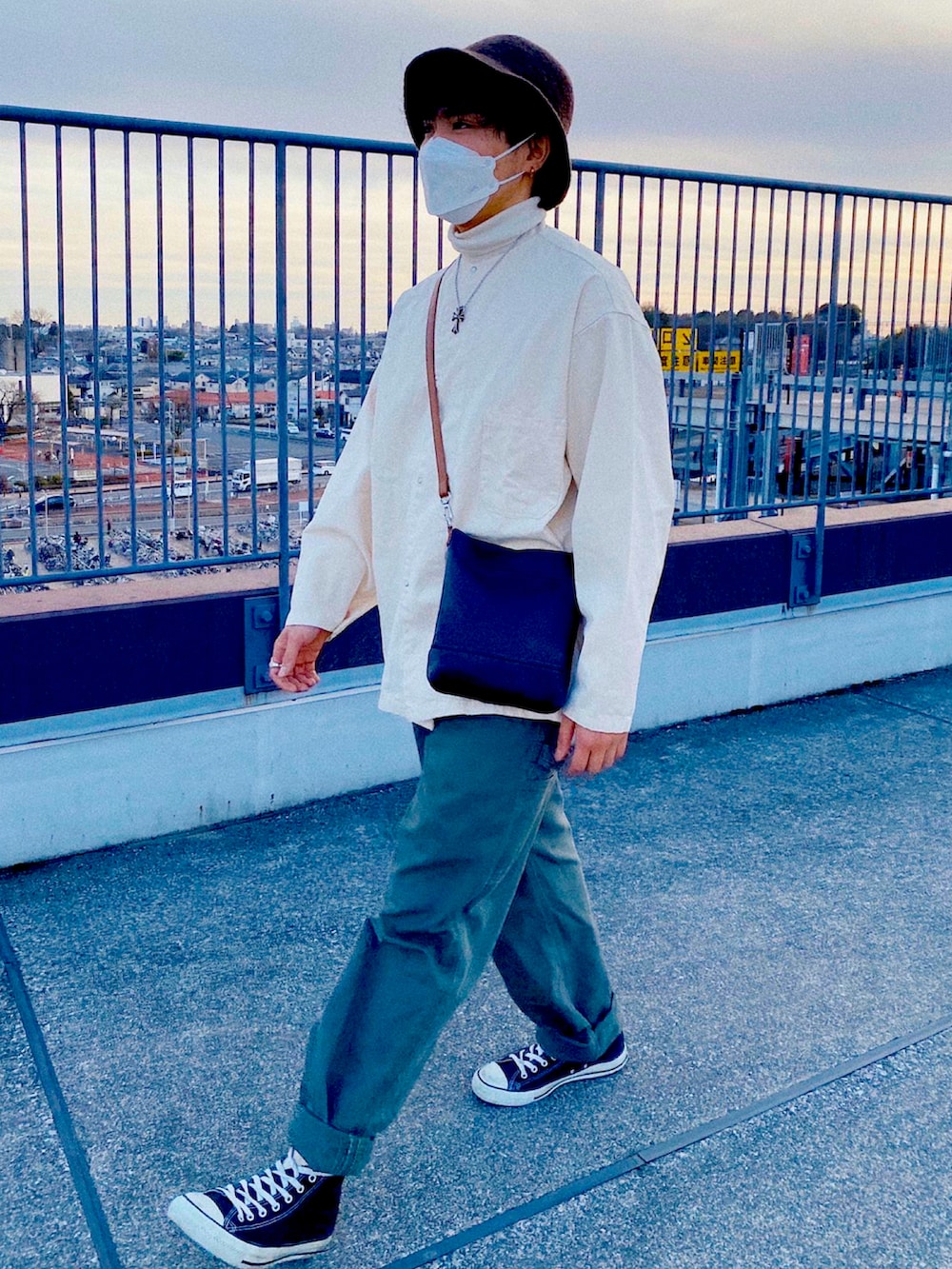 グリーン系のカーゴパンツ、ホワイト系のニット/セーター、ホワイト系のシャツ/ブラウスを着用したメンズの冬コーディネートの2枚目の写真