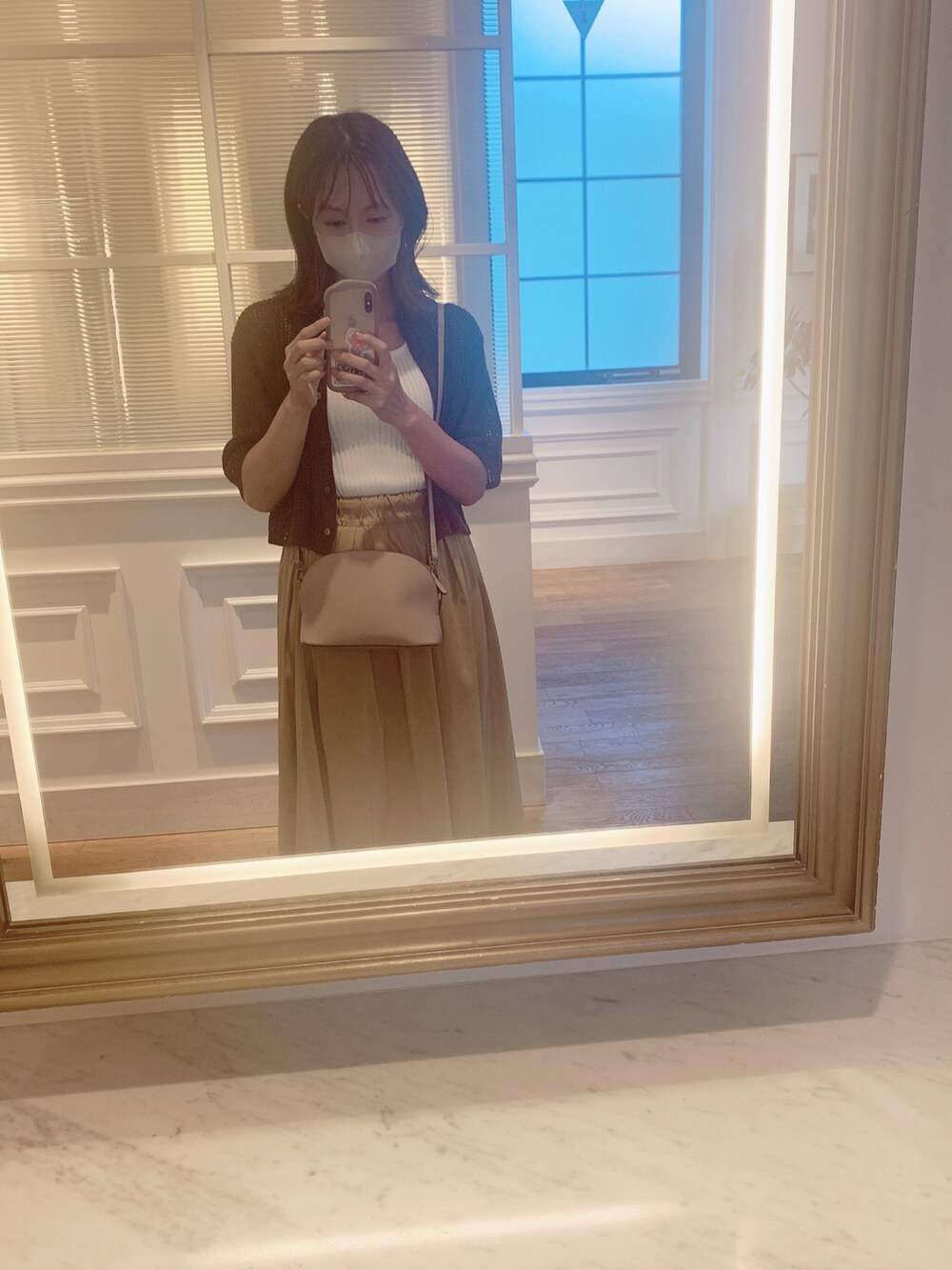 ブラウン系のシャツ/ブラウス、ホワイト系のタンクトップ、ベージュ系のショルダーバッグを着用したレディースの秋コーディネートの2枚目の写真