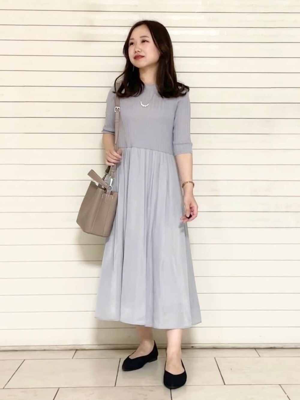 ブラック系のパンプス、ホワイト系のトートバッグ、グレー系のワンピースを着用したレディースの夏コーディネートの4枚目の写真
