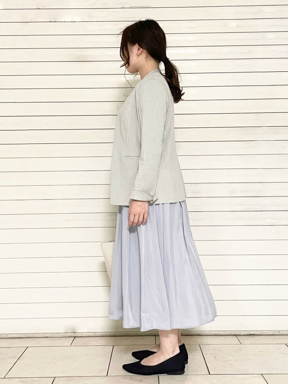 ブラック系のパンプス、ホワイト系のトートバッグ、グレー系のワンピースを着用したレディースの夏コーディネートの3枚目の写真