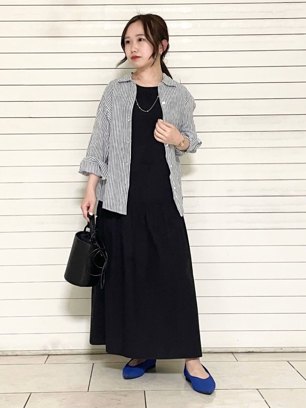 ブラック系のサンダル、ホワイト系のショルダーバッグ、ブラック系のセットアップを着用したレディースの春コーディネートの5枚目の写真