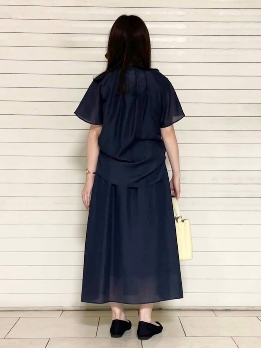 ブラック系のパンプス、イエロー系のショルダーバッグ、グレー系のシャツ/ブラウスを着用したレディースの春コーディネートの3枚目の写真