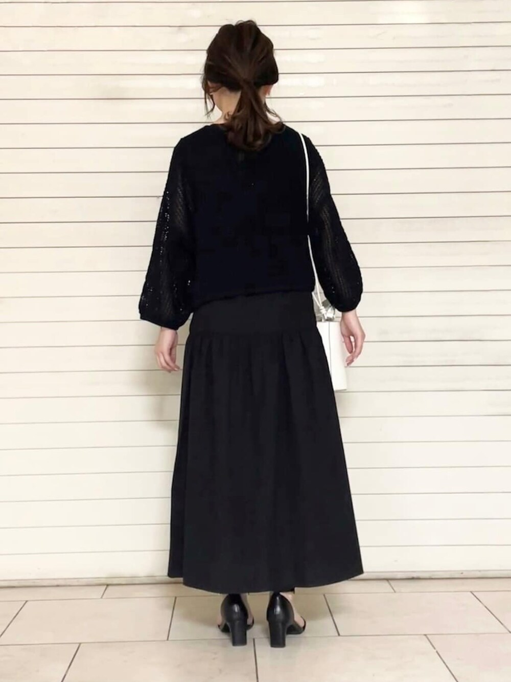 ブラック系のサンダル、ホワイト系のショルダーバッグ、ブラック系のセットアップを着用したレディースの春コーディネートの3枚目の写真