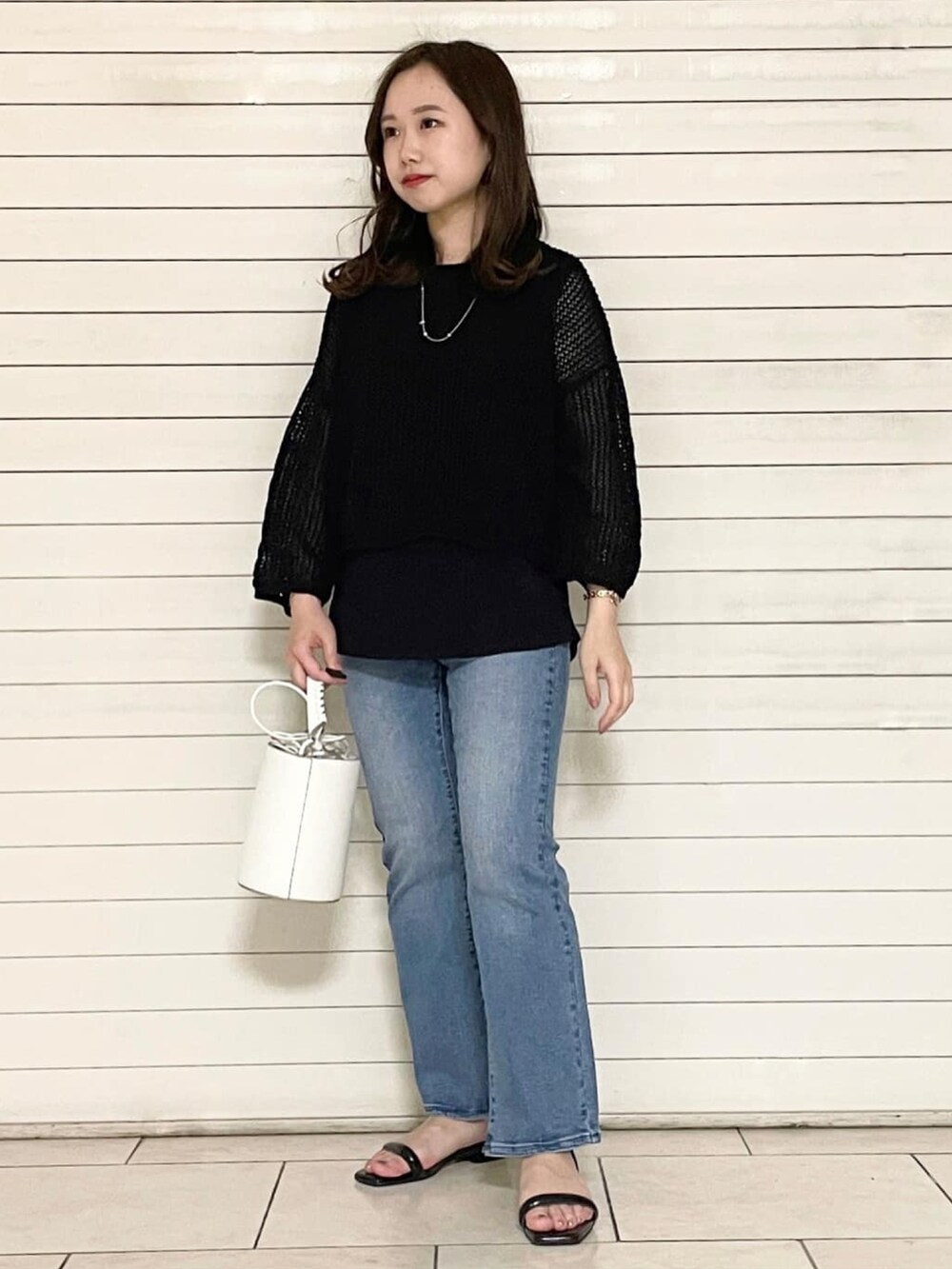 ブラック系のサンダル、ホワイト系のショルダーバッグ、ブラック系のセットアップを着用したレディースの春コーディネートの4枚目の写真