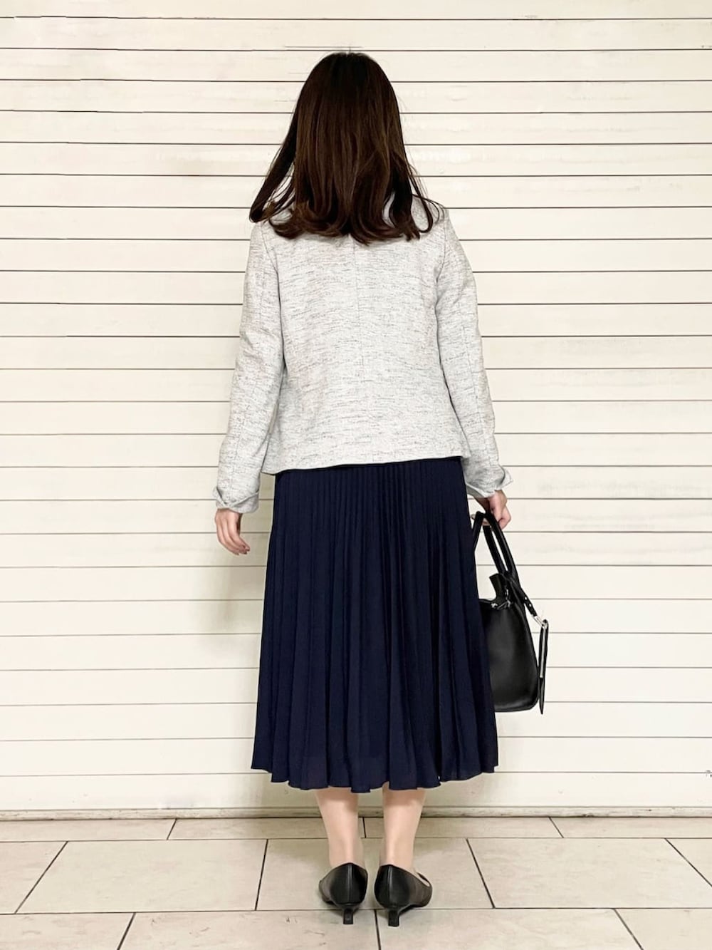 ホワイト系のシャツ/ブラウス、ブルー系のスカート、ブラック系のパンプスを着用したレディースの春コーディネートの2枚目の写真