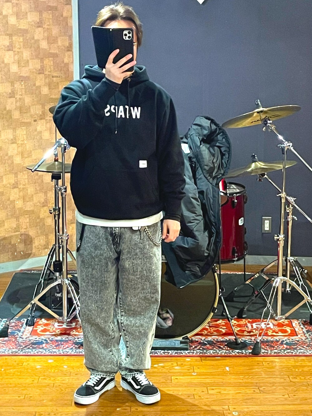 ブラック系のナイロンジャケット、ブラック系のパーカー、グレー系のデニムパンツを着用したメンズの春コーディネートの4枚目の写真