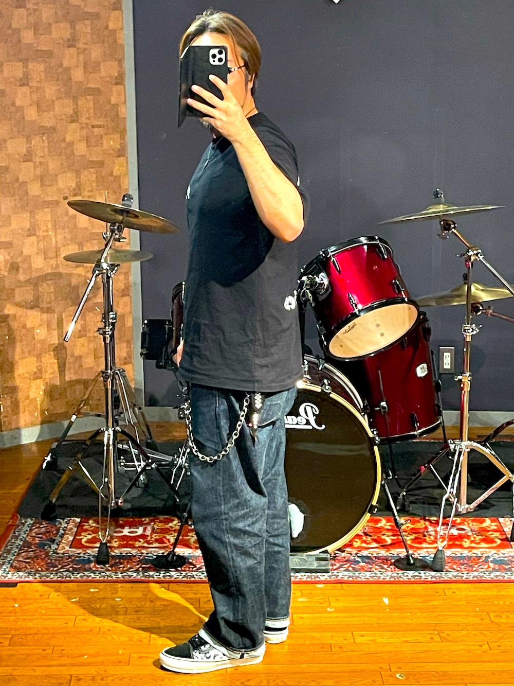 ブラック系のTシャツ/カットソー、ブルー系のデニムパンツ、ブラック系のスニーカーを着用したメンズの秋コーディネートの4枚目の写真