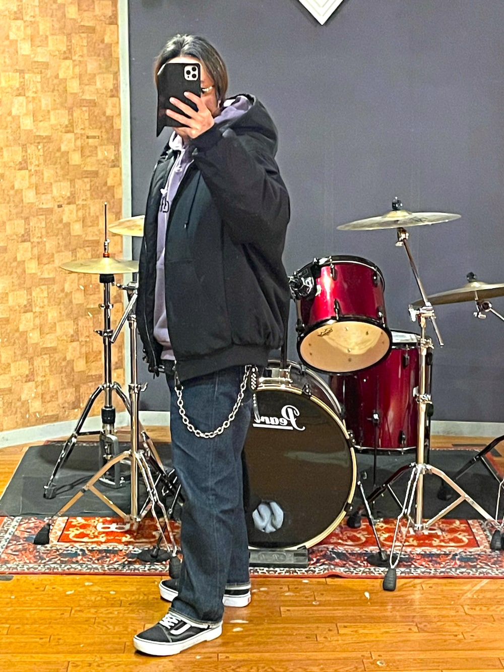 ブラック系のナイロンジャケット、パープル系のパーカー、ブルー系のデニムパンツを着用したメンズの冬コーディネートの2枚目の写真