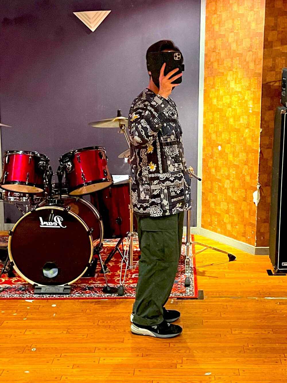 ブラック系のシャツ/ブラウス、グリーン系のカーゴパンツ、ブラック系のスニーカーを着用したメンズの春コーディネートの2枚目の写真