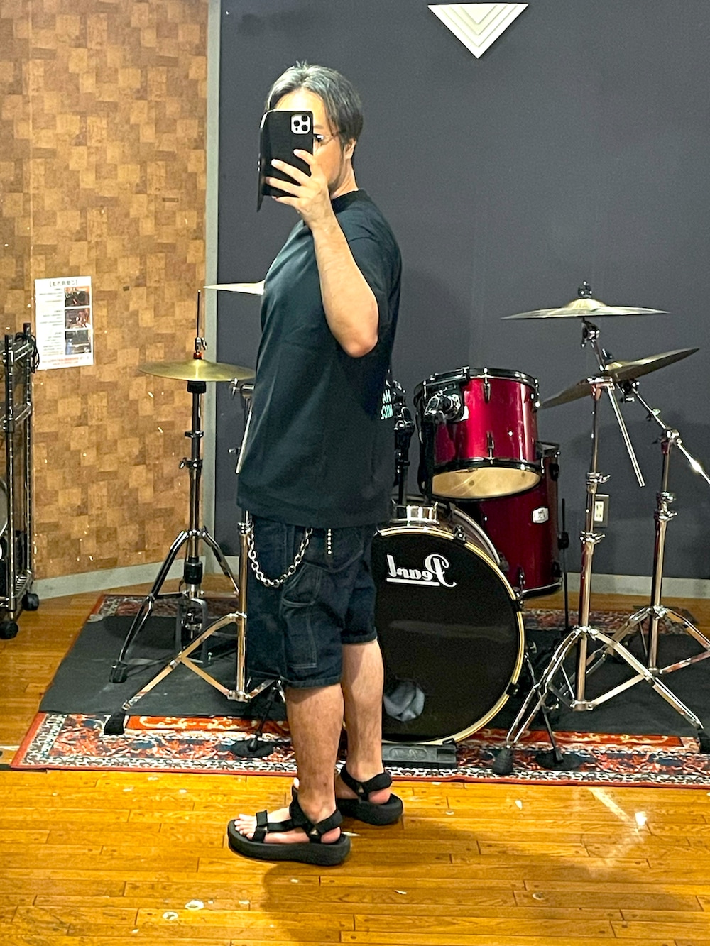 ブラック系のTシャツ/カットソー、ブルー系のデニムパンツ、ブラック系のサンダルを着用したメンズの夏コーディネートの2枚目の写真