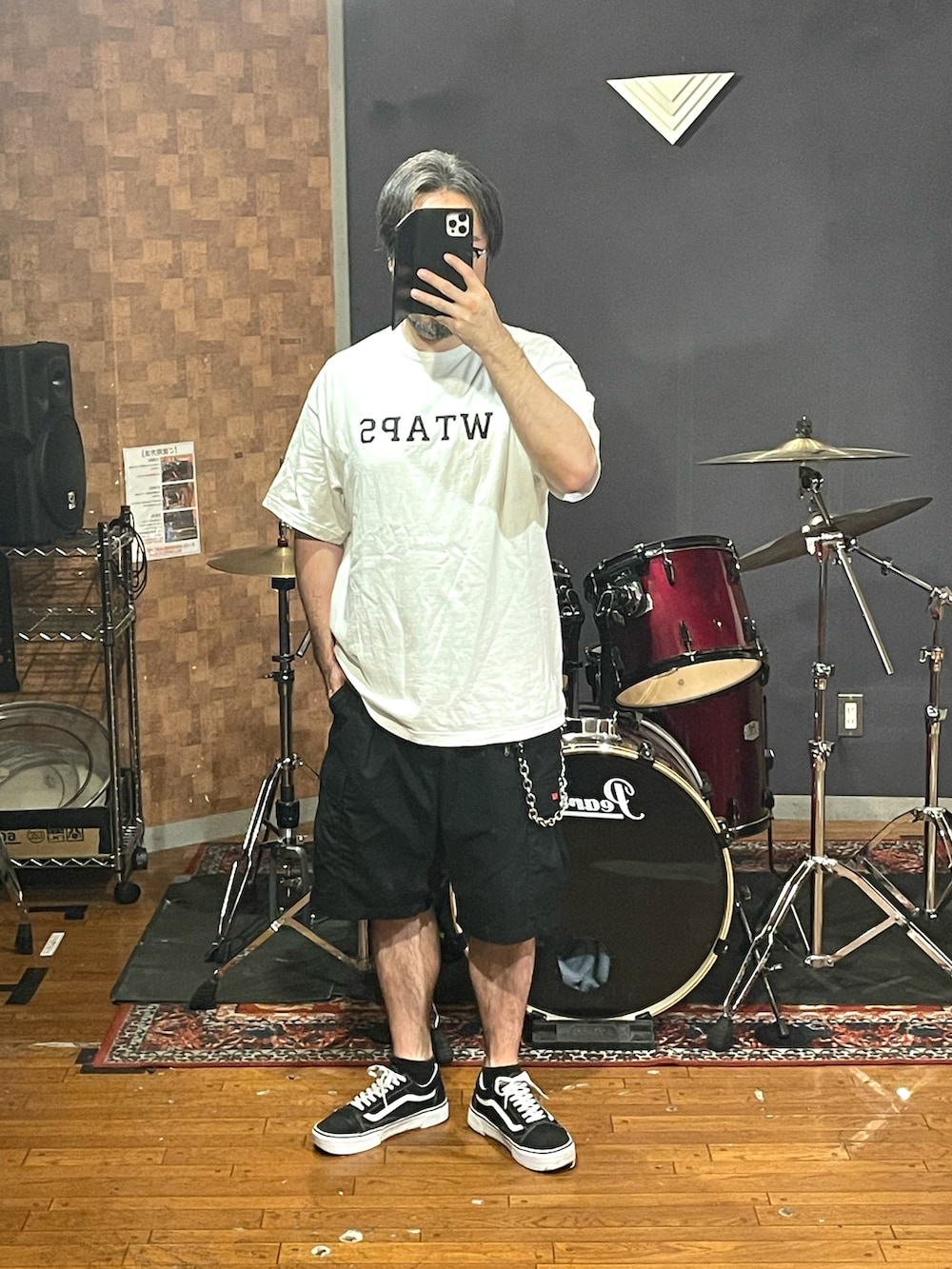ホワイト系のTシャツ/カットソー、ブラック系のカーゴパンツ、ブラック系のスニーカーを着用したメンズの秋コーディネートの4枚目の写真