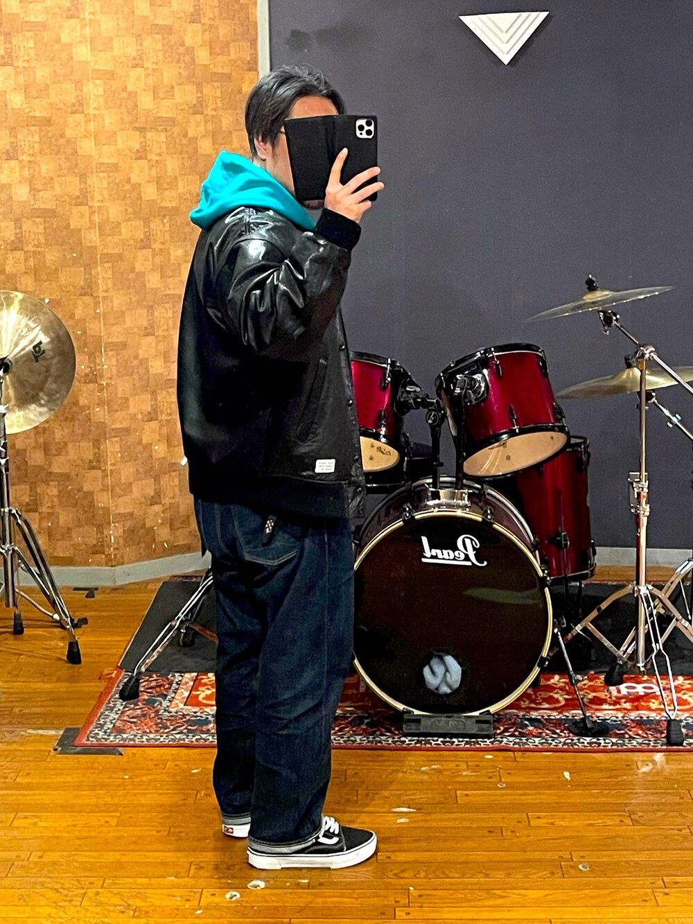 ブラック系のスタジャン、グリーン系のパーカー、ブルー系のデニムパンツを着用したメンズの春コーディネートの3枚目の写真