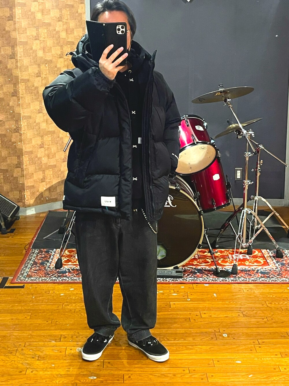 ブラック系のダウンジャケット/コート、ブラック系のパーカー、ブラック系のデニムパンツを着用したメンズの冬コーディネートの4枚目の写真