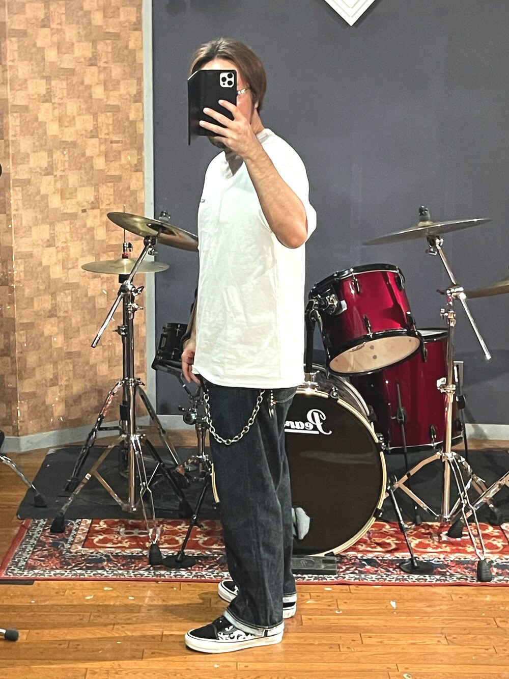 ホワイト系のTシャツ/カットソー、ブルー系のデニムパンツ、ブラック系のスニーカーを着用したメンズの秋コーディネートの3枚目の写真