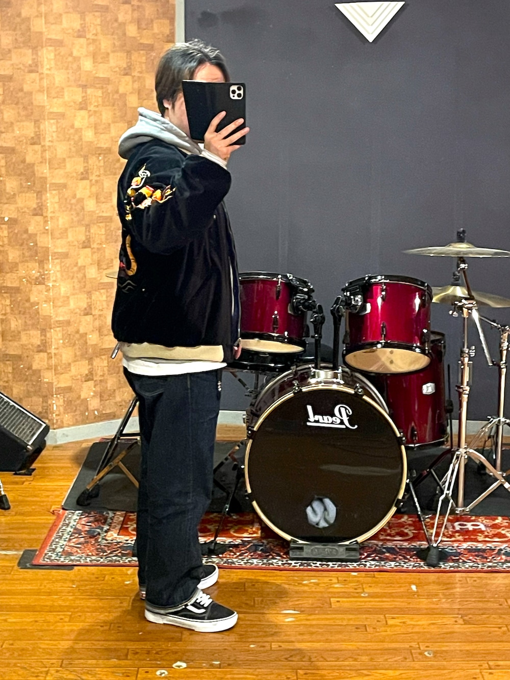 ブラック系のスカジャン、グレー系のパーカー、ブルー系のデニムパンツを着用したメンズの冬コーディネートの3枚目の写真