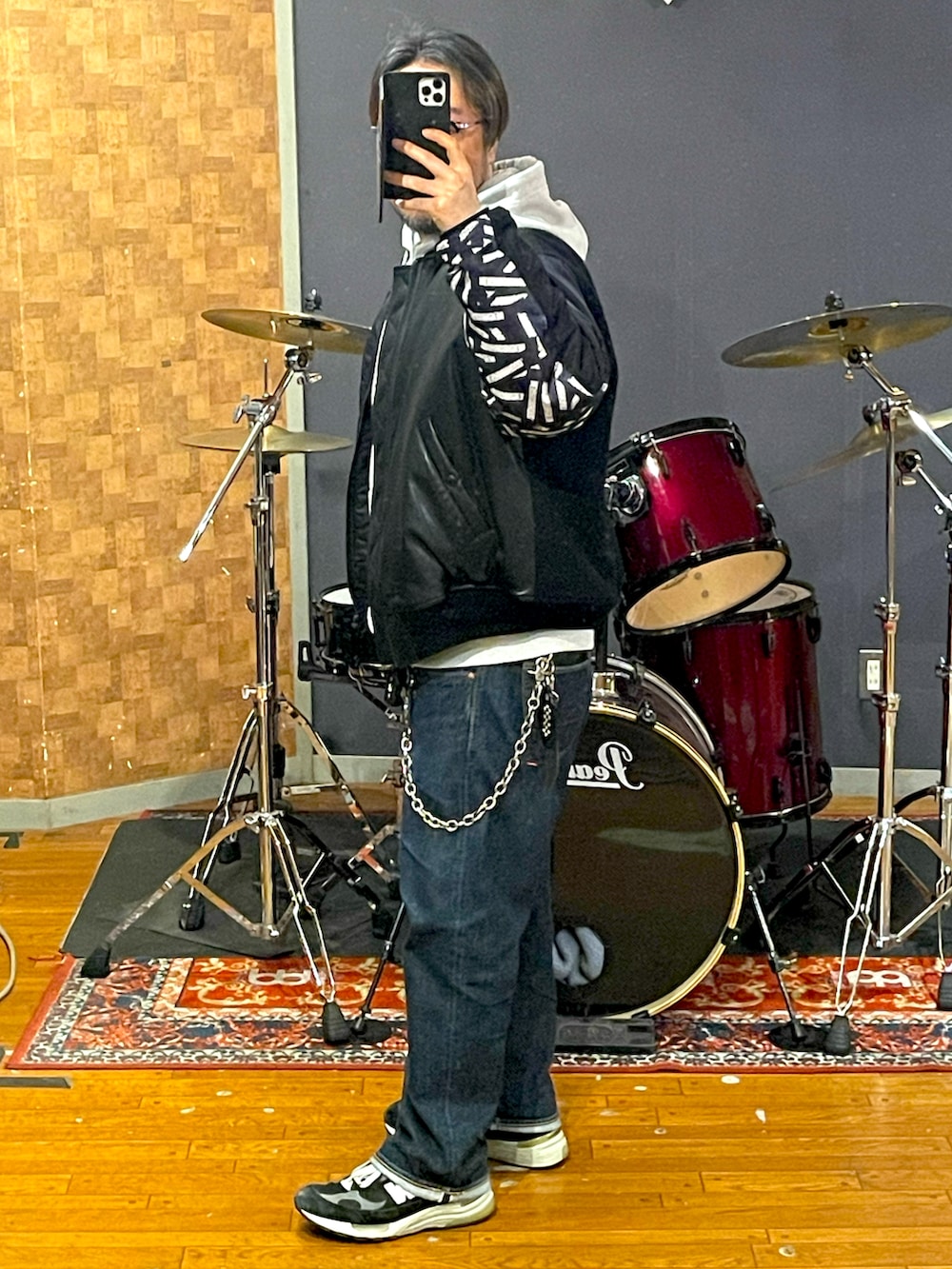 ブラック系のMA-1、グレー系のパーカー、ブルー系のデニムパンツを着用したメンズの春コーディネートの2枚目の写真