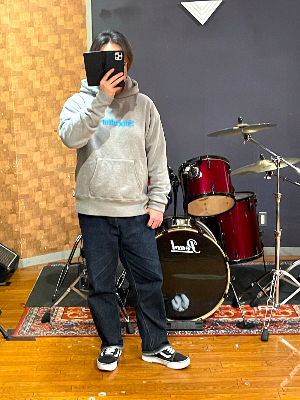 ブラック系のナイロンジャケット、グレー系のパーカー、ブルー系のデニムパンツを着用したメンズの冬コーディネートの4枚目の写真