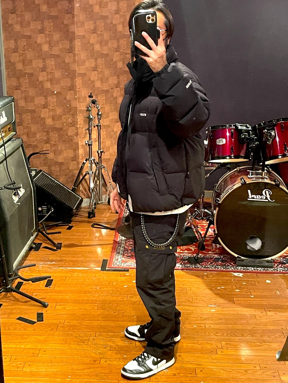 ブラック系のダウンジャケット/コート、ホワイト系のTシャツ/カットソー、ブラック系のカーゴパンツを着用したメンズの冬コーディネートの3枚目の写真