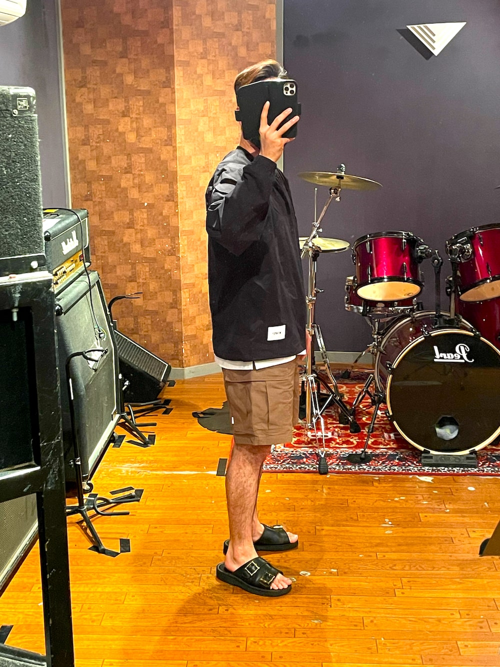 ブラック系のトップス、ベージュ系のカーゴパンツ、ブラック系のサンダルを着用したメンズの夏コーディネートの2枚目の写真