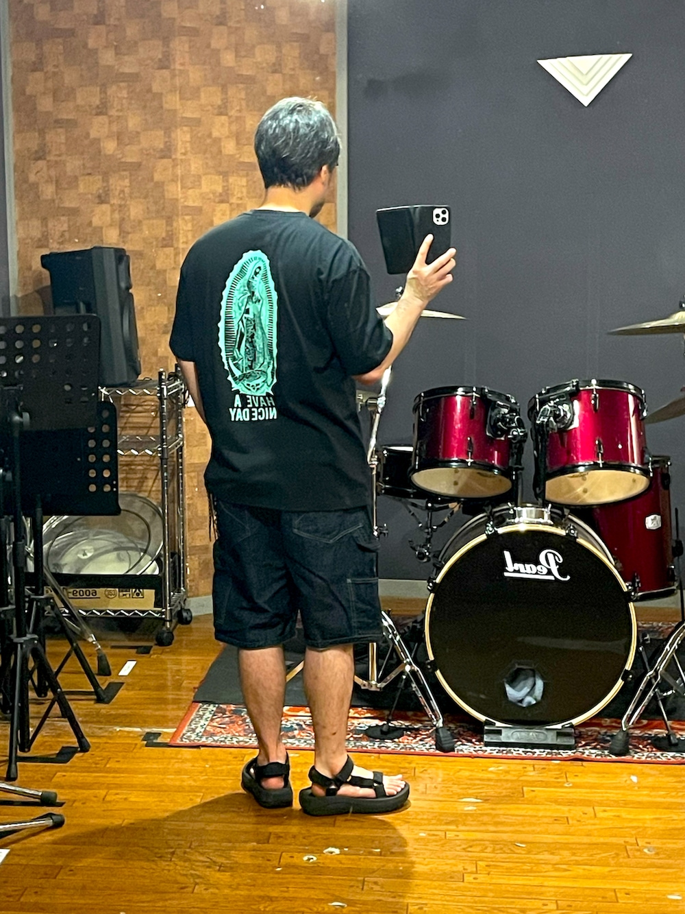 ブラック系のTシャツ/カットソー、ブルー系のデニムパンツ、ブラック系のサンダルを着用したメンズの夏コーディネートの3枚目の写真