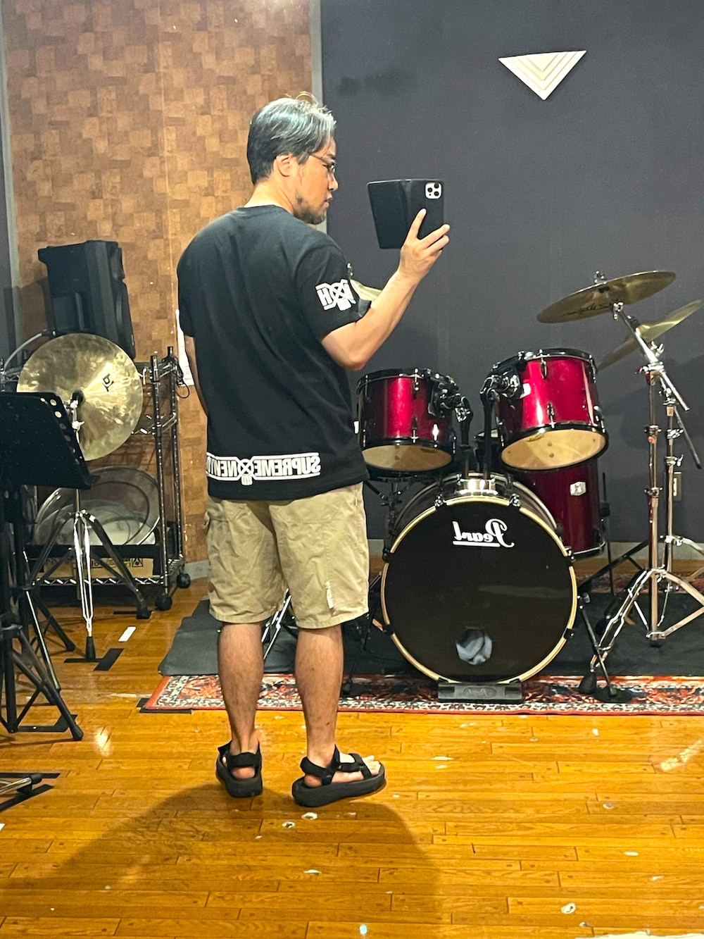 ブラック系のTシャツ/カットソー、ベージュ系のパンツ、ブラック系のサンダルを着用したメンズの夏コーディネートの4枚目の写真