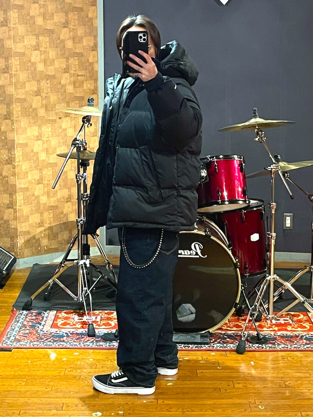 ブラック系のダウンジャケット/コート、ブルー系のデニムパンツ、ブラック系のスニーカーを着用したメンズの冬コーディネートの2枚目の写真