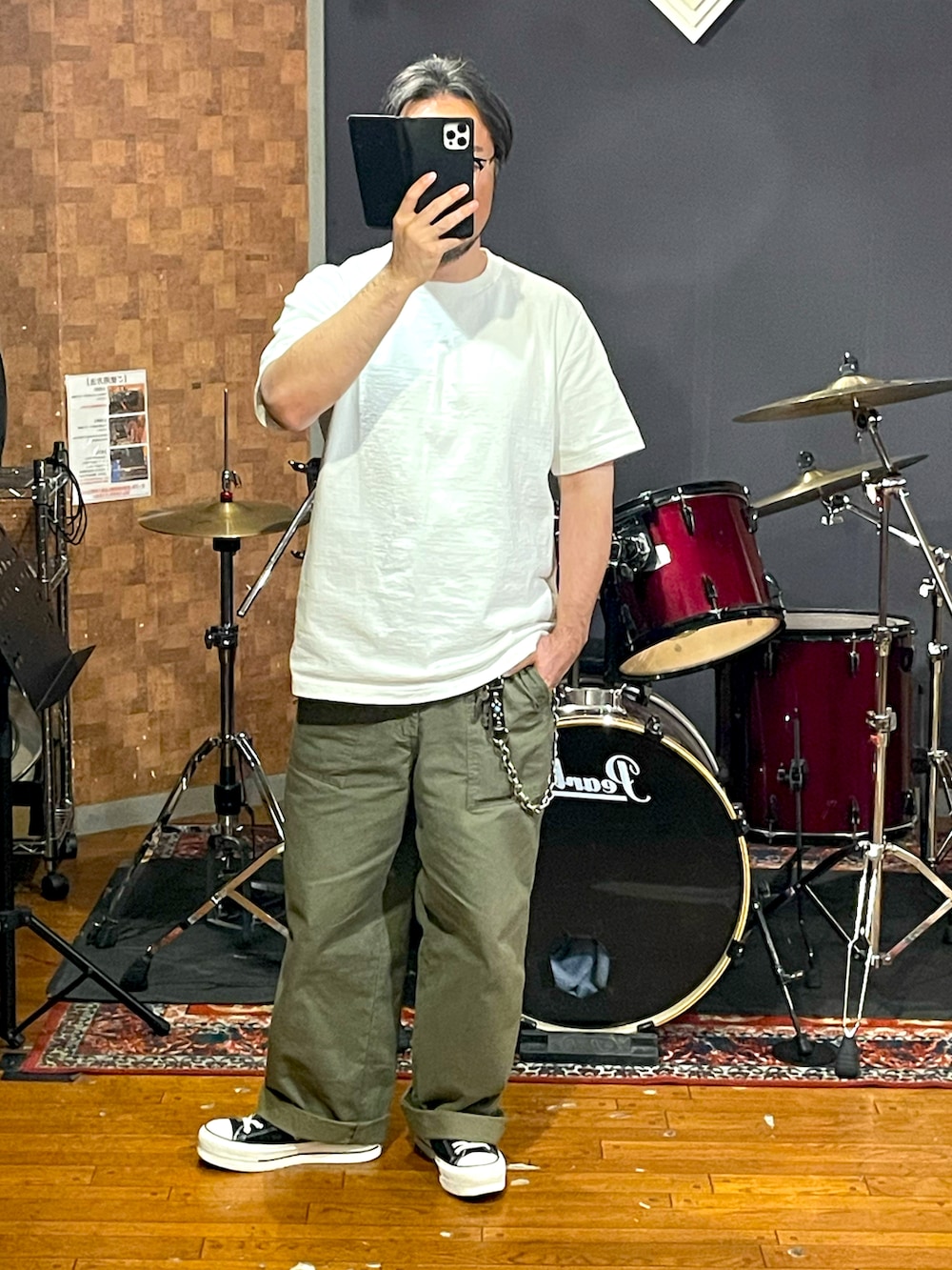 ホワイト系のTシャツ/カットソー、グリーン系のパンツ、ブラック系のスニーカーを着用したメンズの秋コーディネートの3枚目の写真